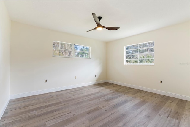 empty room with ceiling fan, plenty of natural light, and light wood-type flooring