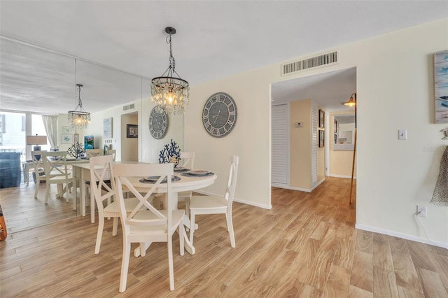 dining area featuring light wood-type flooring, visible vents, and baseboards