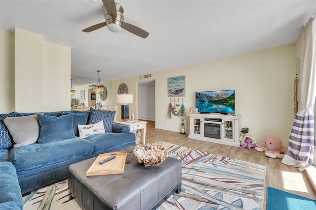 living room featuring ceiling fan, visible vents, and wood finished floors