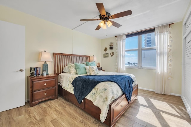 bedroom with light wood-style floors, baseboards, and ceiling fan