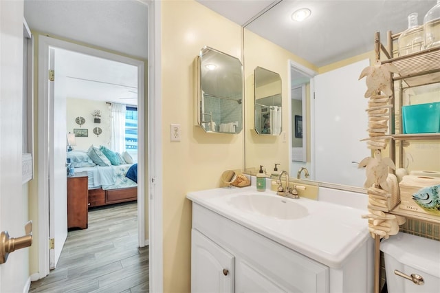 ensuite bathroom with vanity, wood finished floors, and ensuite bathroom