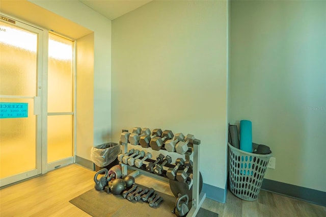 workout room featuring baseboards and wood finished floors