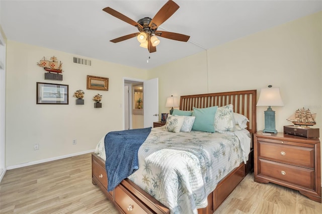 bedroom featuring light wood finished floors, visible vents, ceiling fan, and baseboards