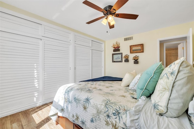 bedroom with visible vents, wood finished floors, and a ceiling fan