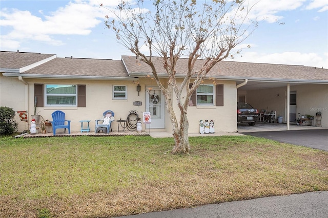 rear view of property featuring a lawn and a carport