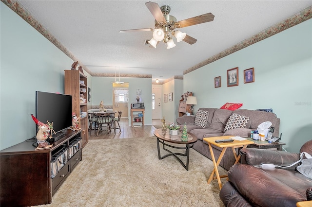 living room with a textured ceiling and ceiling fan