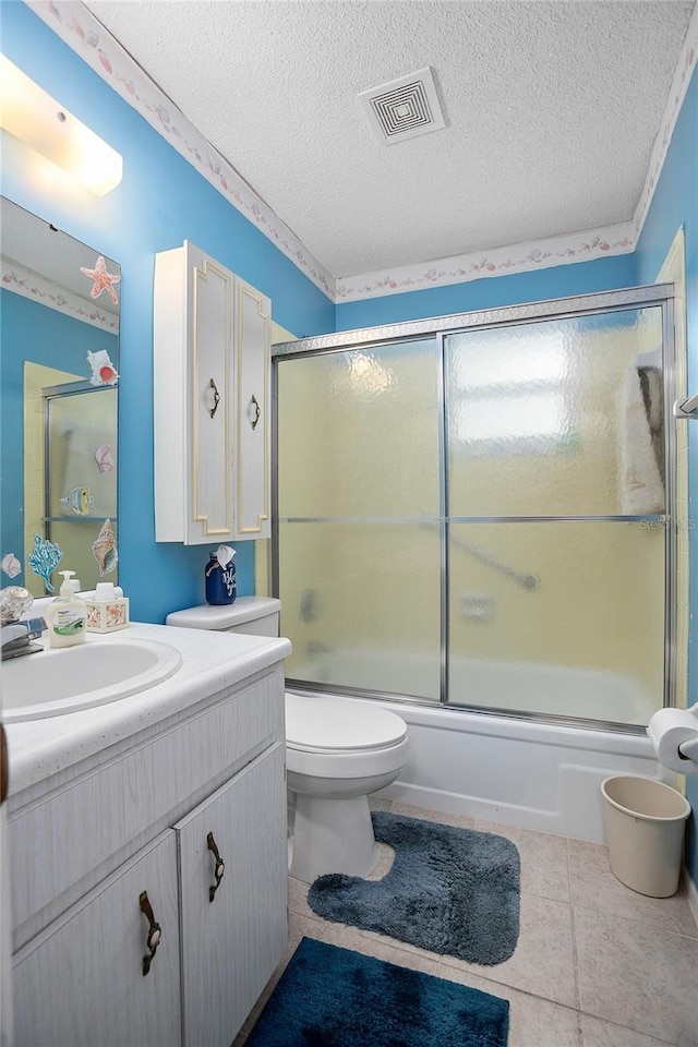 full bathroom featuring toilet, vanity, a textured ceiling, and combined bath / shower with glass door