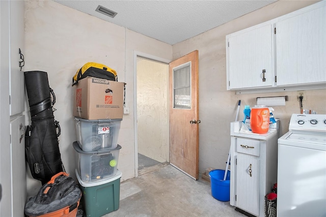 clothes washing area with cabinets, washer / dryer, and a textured ceiling