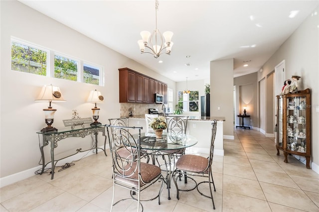 dining space featuring a notable chandelier, light tile patterned flooring, and plenty of natural light