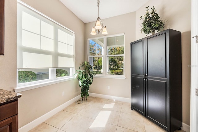 dining space with a notable chandelier and light tile patterned flooring