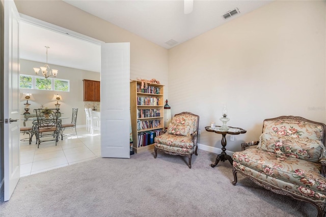 living area with light tile patterned flooring and an inviting chandelier