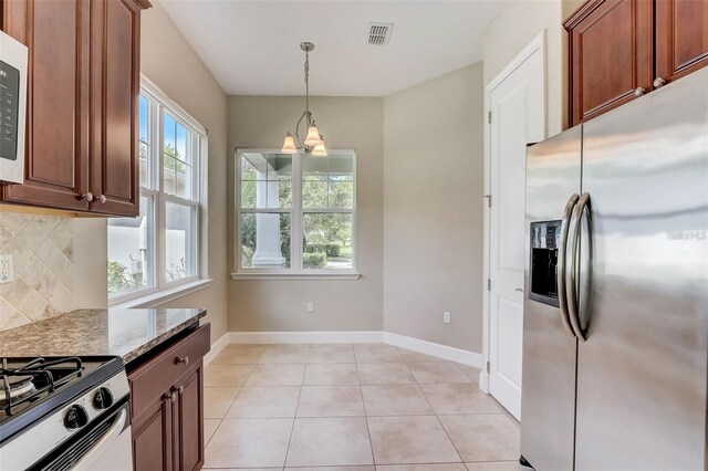 430 Cypress Hills Way, Deland, FL 32724 - kitchen with appliances with stainless steel finishes, decorative backsplash, hanging light fixtures, a chandelier, and light stone countertops