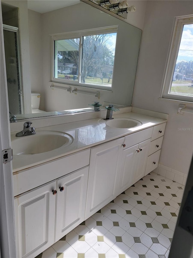 bathroom featuring walk in shower, vanity, and toilet