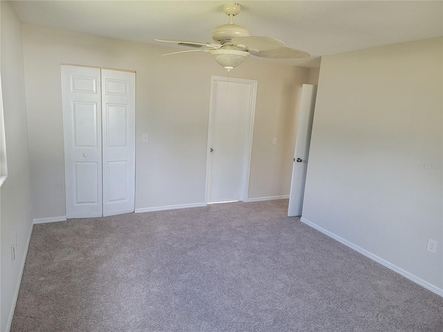 unfurnished bedroom with ceiling fan, light colored carpet, and a closet