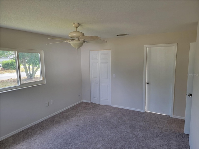 unfurnished bedroom with carpet floors, a closet, and ceiling fan