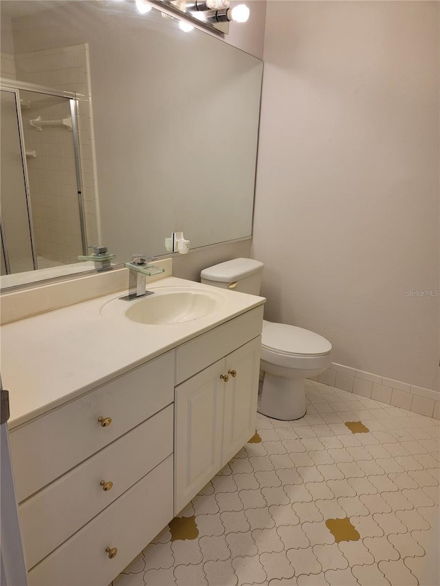 bathroom featuring vanity, toilet, and a shower with door