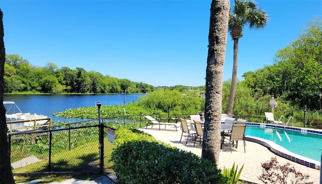 view of swimming pool featuring a patio area and a water view