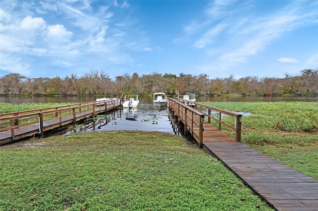 view of dock featuring a water view and a lawn