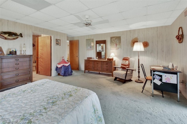 bedroom featuring ceiling fan, a drop ceiling, and carpet