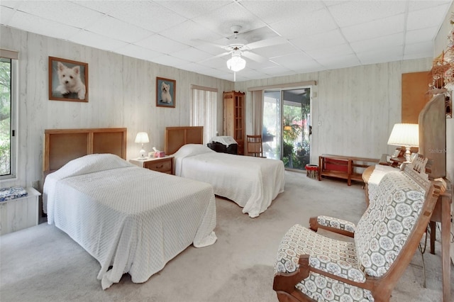 carpeted bedroom featuring a paneled ceiling, ceiling fan, and access to outside