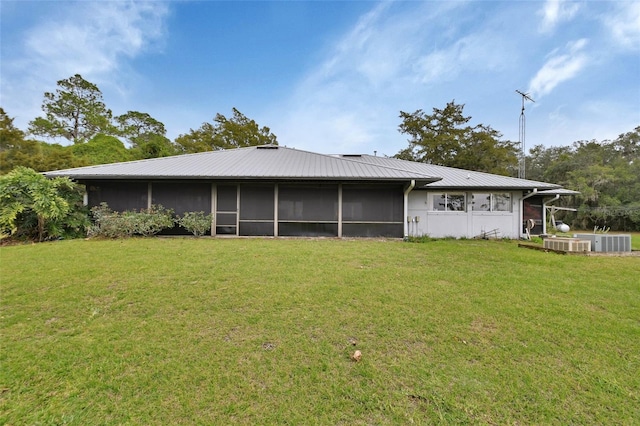 rear view of house featuring a yard and a sunroom