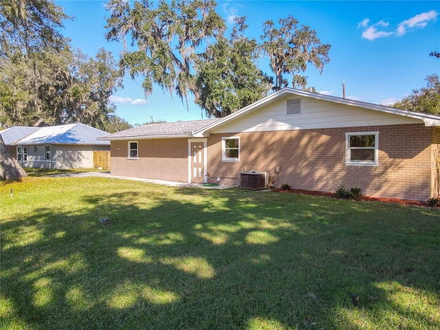 back of house with a lawn and central AC