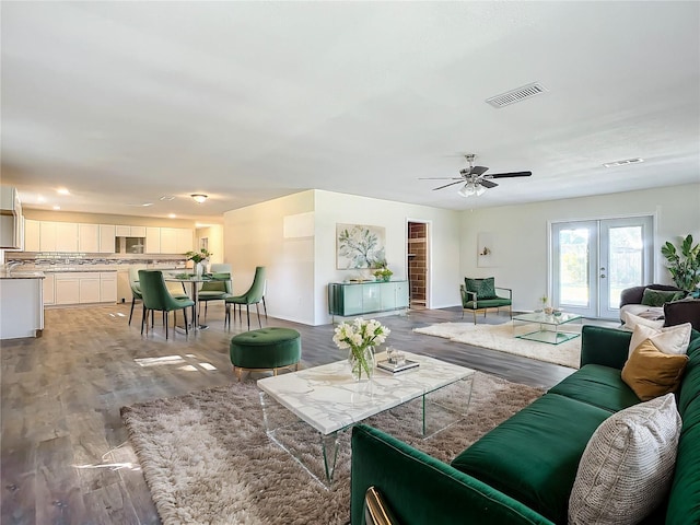 living room featuring hardwood / wood-style flooring, ceiling fan, and french doors