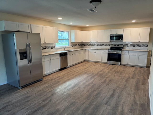 kitchen with white cabinetry, sink, wood-type flooring, and appliances with stainless steel finishes