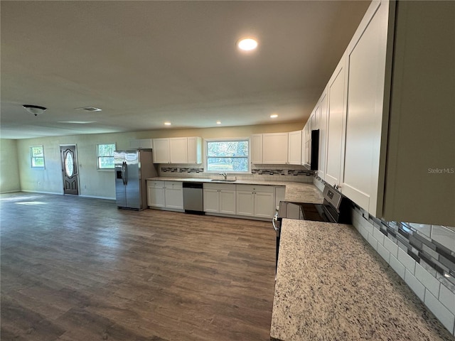 kitchen featuring white cabinets, sink, light stone countertops, appliances with stainless steel finishes, and dark hardwood / wood-style flooring