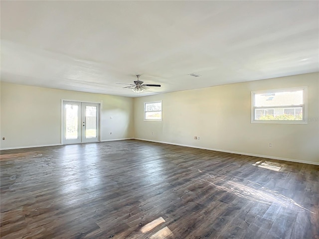 spare room with ceiling fan, french doors, and dark wood-type flooring