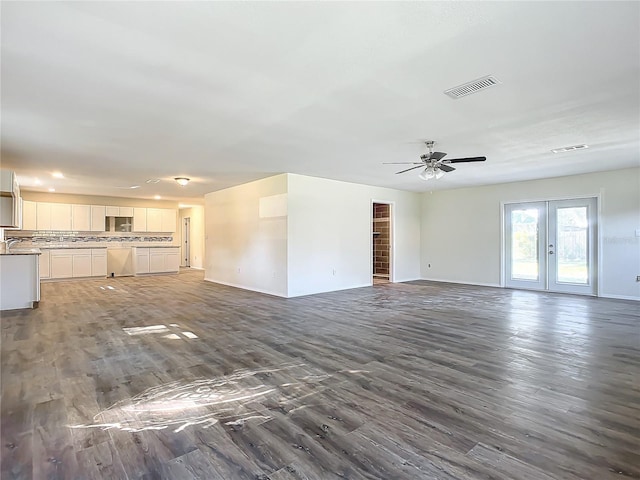 unfurnished living room featuring ceiling fan, dark wood-type flooring, and french doors