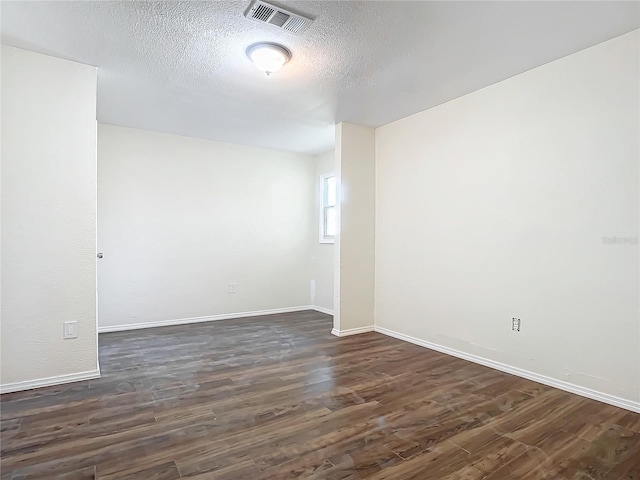 unfurnished room featuring a textured ceiling and dark hardwood / wood-style floors