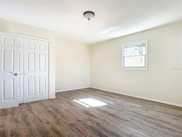 unfurnished bedroom featuring dark hardwood / wood-style flooring and a closet