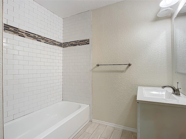 bathroom featuring tiled shower / bath combo and vanity