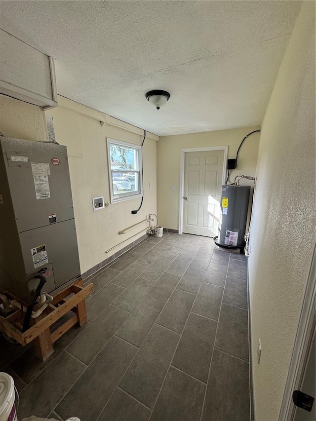 clothes washing area with heating unit, water heater, and a textured ceiling