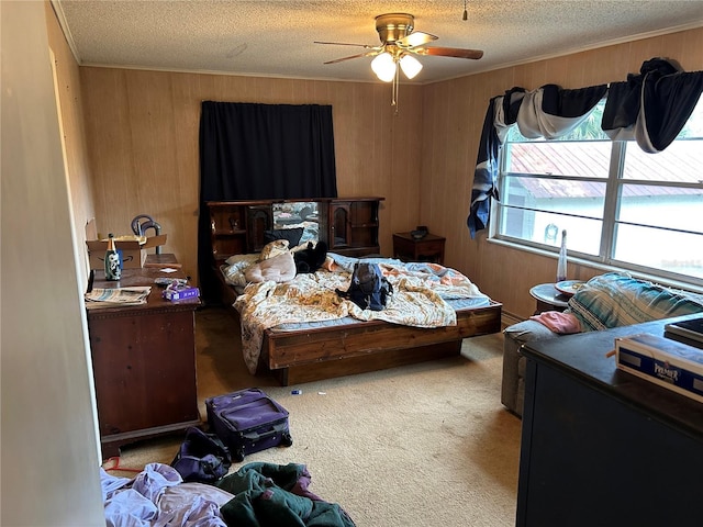 carpeted bedroom with ceiling fan, a textured ceiling, and wooden walls