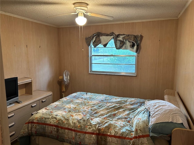 bedroom with ceiling fan, wood walls, ornamental molding, and a textured ceiling