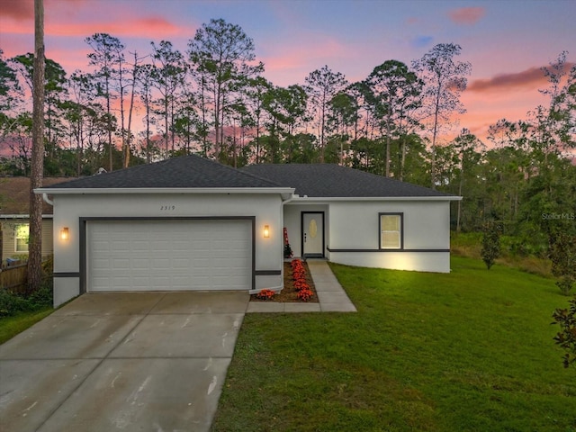 view of front of home featuring a lawn and a garage