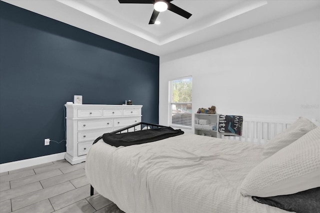 bedroom with a raised ceiling and ceiling fan