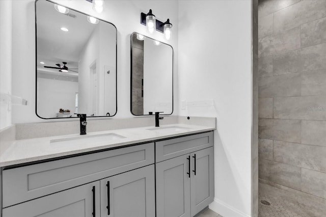 bathroom featuring ceiling fan, vanity, and tiled shower