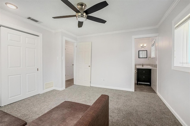 unfurnished bedroom featuring carpet, ceiling fan, ornamental molding, and connected bathroom