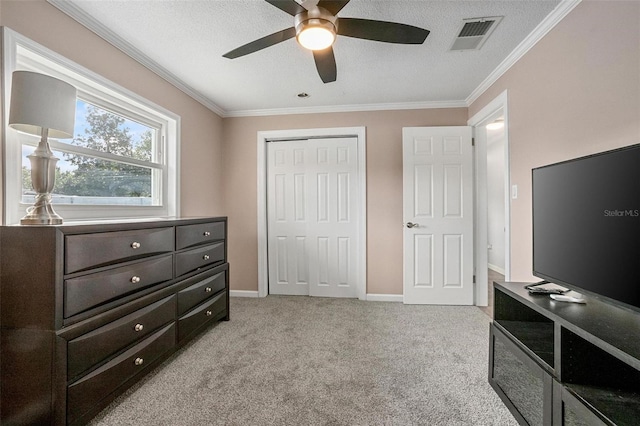 bedroom with a closet, light colored carpet, ceiling fan, and ornamental molding