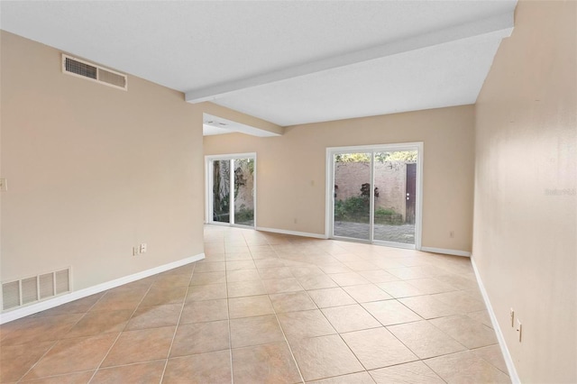 tiled spare room with beamed ceiling