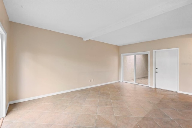 empty room with beamed ceiling and light tile patterned floors