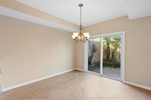 empty room with a chandelier and light tile patterned flooring