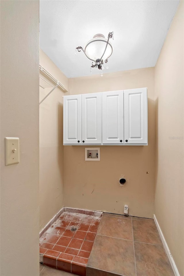 washroom featuring cabinets, washer hookup, light tile patterned floors, and hookup for an electric dryer