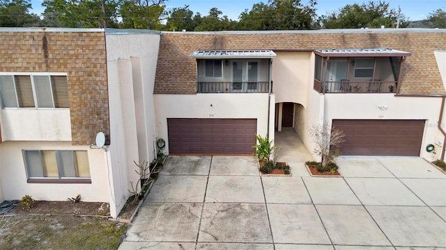 view of property featuring a garage and a balcony