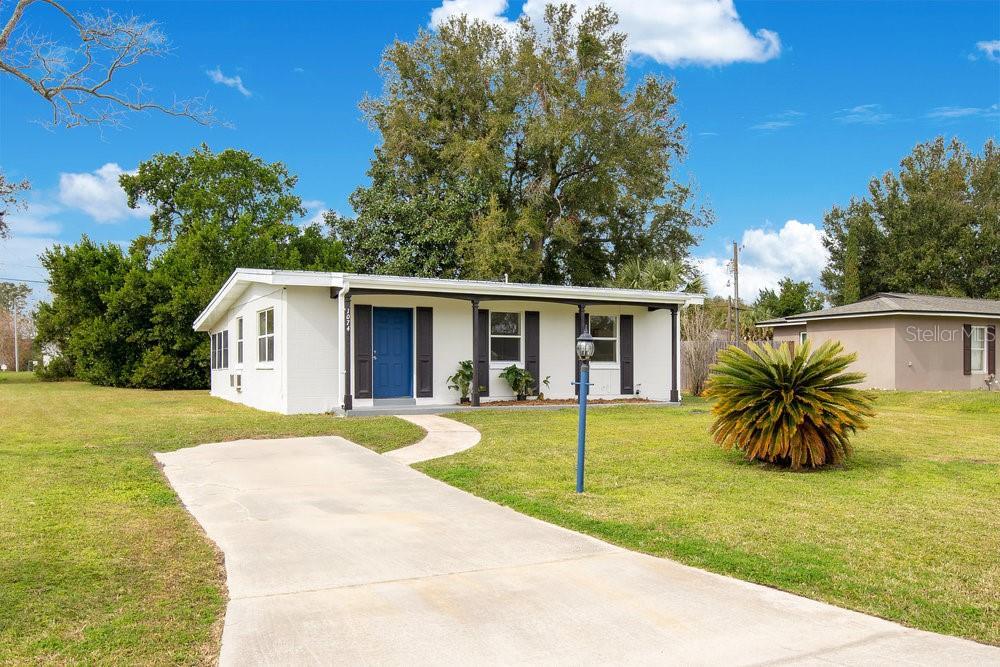 ranch-style house with covered porch and a front yard