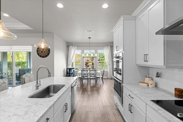 kitchen featuring light stone countertops, white cabinetry, sink, and stainless steel appliances