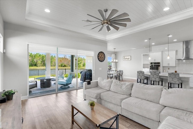 living room with ceiling fan, a raised ceiling, wooden ceiling, and light hardwood / wood-style flooring